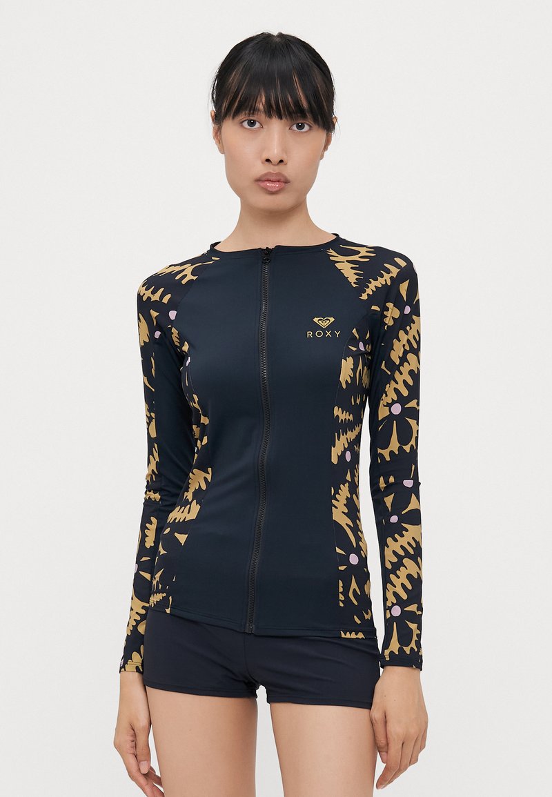 Roxy long-sleeve swim top in navy with a zip front. Features gold and beige abstract pattern, fitted design, and soft, stretchy fabric.