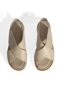 Beige lederen sandalen met een kruisriemontwerp, open hiel en een gestructureerde zool. Kenmerkt zich door minimale stiksels en een merklogo dat in de binnenzool is gedrukt.