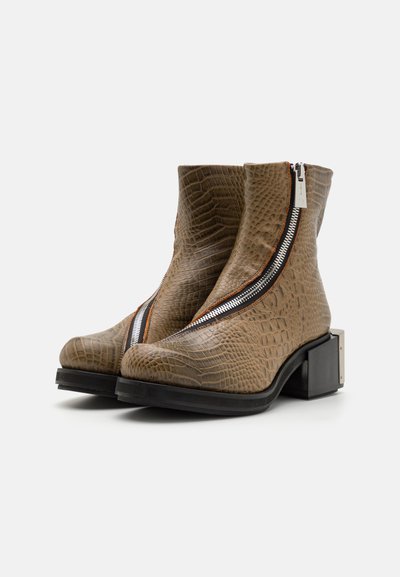 Bocanci până la glezne din material sintetic de crocodil maro, cu un design elegant, dotate cu închidere cu fermoar lateral și toc pătrat. Suprafață texturată și accente contrastante.