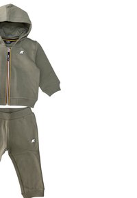 Felpa aderente khaki con zip e pantaloni abbinati. Presenta polsini a coste e un piccolo logo su entrambi i capi. Realizzato in morbido cotone misto.