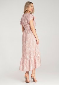 Maxi sukienka w różowym odcieniu tkaniny z białymi haftami kwiatowymi, z krótkimi falbaniastymi rękawami, paskiem w talii oraz warstwowym dołem z falbaną.