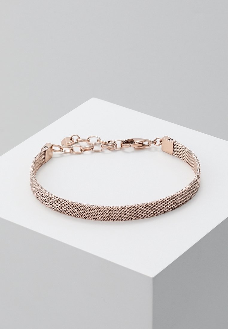Armbånd med rosaguldfarvet meshkæde med justerbar hummerlås, udstillet på hvid geometrisk platform mod en grå baggrund.
