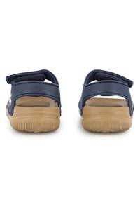 Σανδάλια σε ναυτικό μπλε χρώμα με ρυθμιζόμενους ιμάντες βέλκρο, ανοιχτή πτέρνα και υφασμένες, ελαφρώς καφέ λαστιχένιες σόλες. Κατάλληλα για καθημερινή χρήση.