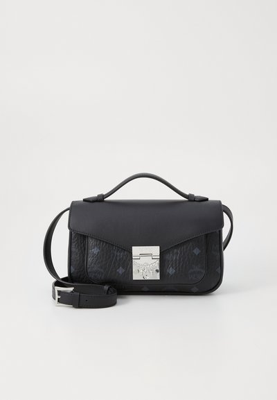Schwarze Lederhandtasche mit einem glatten oberen Abschnitt und einem strukturierten unteren Abschnitt mit eingeprägten Mustern. Silberne Hardware-Verschluss und abnehmbarer Trageriemen.