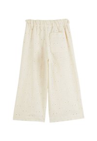 Pantalons en coton beige clair avec une coupe ample, dotés d'une taille élastique, de motifs floraux intricats et d'une poche arrière unique.