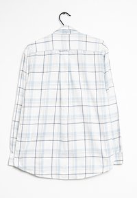 Camisa de manga larga en blanco, con un diseño a cuadros en azul y marino. Tejido ligero con collar abotonado y dobladillo curvado.