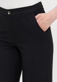 Sorte skræddersyede bukser med en glat stofstruktur, slim fit, sidelommer og en metalknaplukning i taljen.