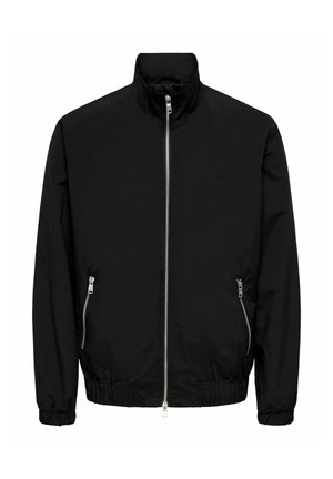 Juoda bombonešio striukė su stovinčiu apykakliu, priekyje užtrauktuku, elastinėmis rankogaliais ir dviem šoninėmis kišenėmis su užtrauktuko detalėmis. Lygi tekstūra.