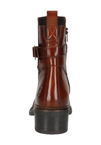 Braune Leder-Stiefelette mit glänzender Oberfläche, seitlichem Reißverschluss und dekorativem Gürtelakzent. Gestapelter Absatz und strukturierte Sohle für besseren Halt.