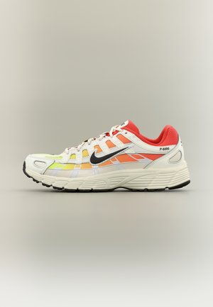 Baskets Nike P-6000 blanches et oranges avec le logo swoosh noir, doublure intérieure rouge, semelle texturée et fermeture à lacets sur un fond neutre.
