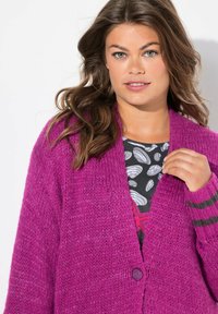 Fuchsia gebreide cardigan met open voorkant, voorzien van een enkele knoopsluiting en gestreepte accenten op de mouwen. Structuurstof.