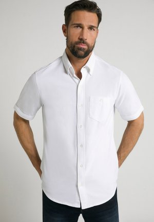 Weißes kurzärmliges Hemd mit Knopfleiste und Tasche, mit Kragen und feiner Textur, kombiniert mit dunklen Jeans.