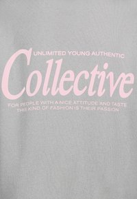 Gray t-shirt featuring pink printed text that includes the word "Collective" and various statements about fashion and attitude.