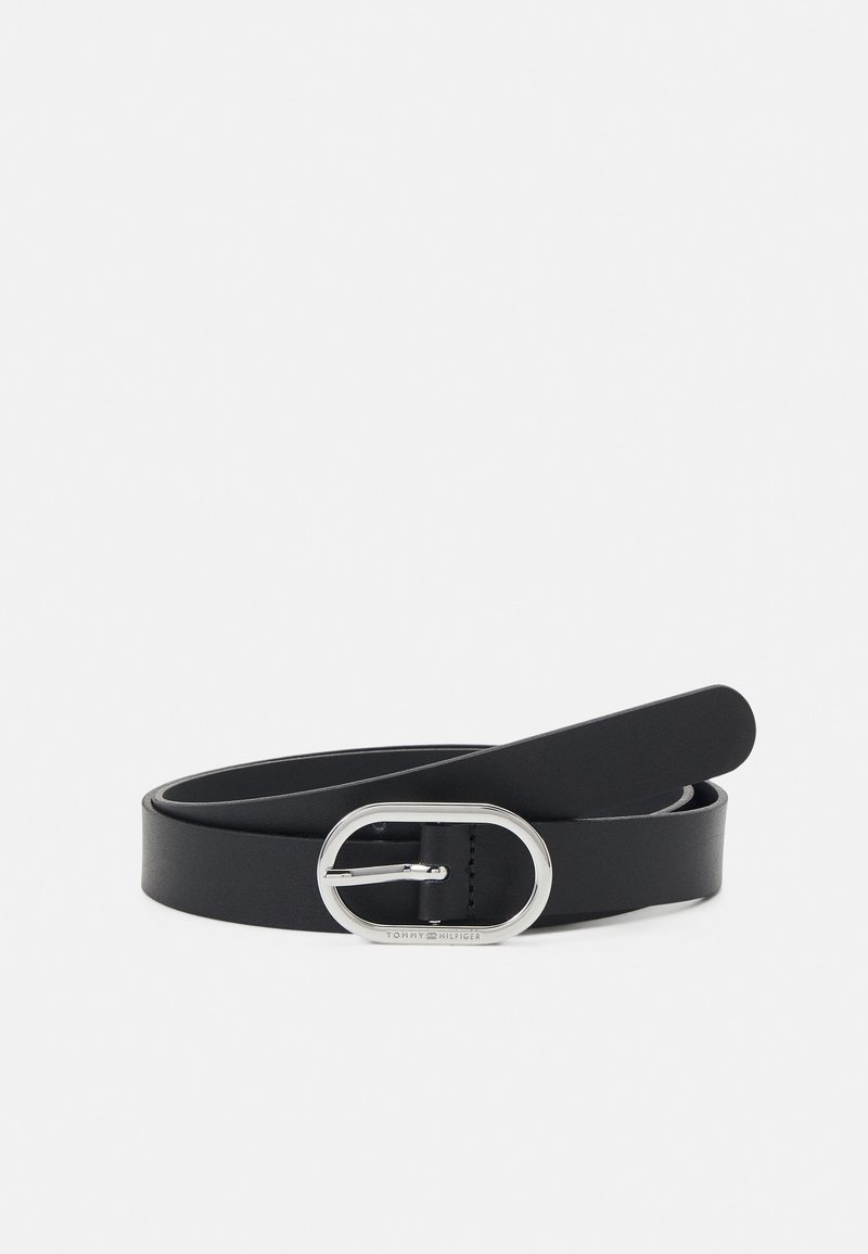 Ceinture en cuir noir avec une boucle ovale argentée et une seule ardillon, enroulée sur un fond blanc.