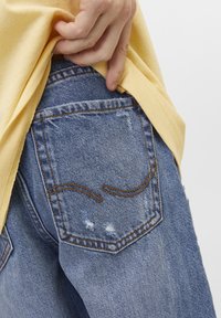 Jeans i denim med en ljusblå färg, med synliga sömdetaljer, en slitstark textur och en standard fickdesign.