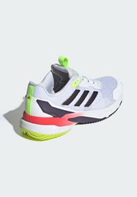 Białe sportowe buty z czarnymi paskami, neonowozielonymi akcentami, teksturowanym cholewką oraz wielokolorową podeszwą z różowymi i fioletowymi wzorami.
