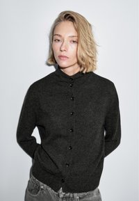 Cardigan lavorato a maglia grigio scuro con colletto alla mandarino, dotato di bottoni scuri e una vestibilità rilassata, realizzato in morbido tessuto testurizzato.