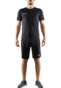 Camiseta atlética negra de manga corta y cuello redondo, combinada con pantalones cortos a juego, ambos con acentos del logo en blanco "CRAFT".