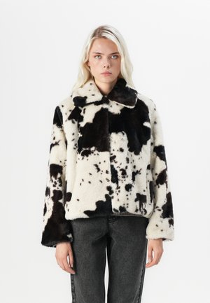 Faux fur jas met een zwart-wit koeienprint, voorzien van een kraag en brede mouwen. Gemêleerde, zachte stof met een boxy vorm.