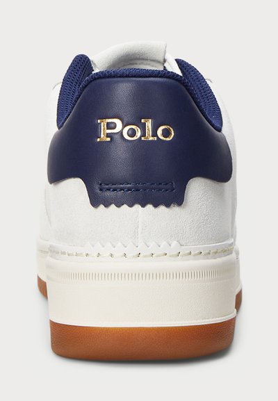 Sapatilha de camurça branca com detalhes em pele azul-marinho e logótipo "Polo" em dourado no calcanhar. Apresenta um colarinho em malha texturizada e sola em borracha.