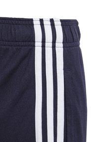 Navy blue shorts with a textured fabric, featuring three vertical white stripes along the side and an elastic waistband with a pocket.