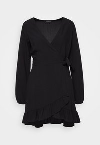 Robe noire portefeuille avec des manches longues, un décolleté en V et un ourlet volants. Dotée d'un lien à la taille et d'une texture de tissu douce.