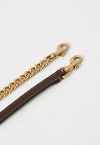 Two gold swivel clasps, one attached to a gold chain and the other to a brown leather strap with stitching.