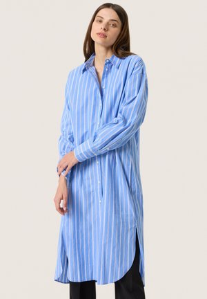 Hellblau gestreiftes Hemdkleid mit Knopfverschluss, langen Ärmeln, Seitenschlitzen und einem lässigen Schnitt. Hergestellt aus einem weichen, leichten Stoff.