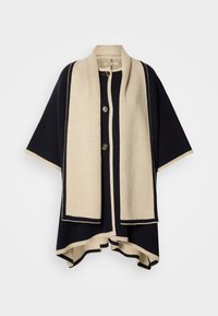 Πλεκτό ποντσο σε ναυτικό μπλε και εκρού με φαρδιά λαιμόκοψη, τρία κουμπιά και δομημένο σχέδιο. Διαθέτει αντίθετες άκρες και απαλό υφή.