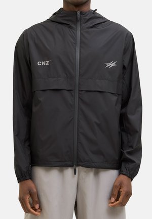 Zwarte windbreakers met een volledige rits, elastische manchetten en capuchon. Voorzien van het "CNZ" logo en een bliksemschichtontwerp in zilver. Lichtgewicht materiaal.