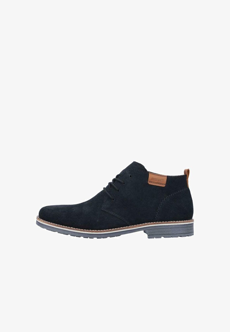 Stivali ankle in suede blu scuro con chiusura a lacci, dettaglio marrone nel tallone e suola chiara. Presentano una superficie testurizzata.