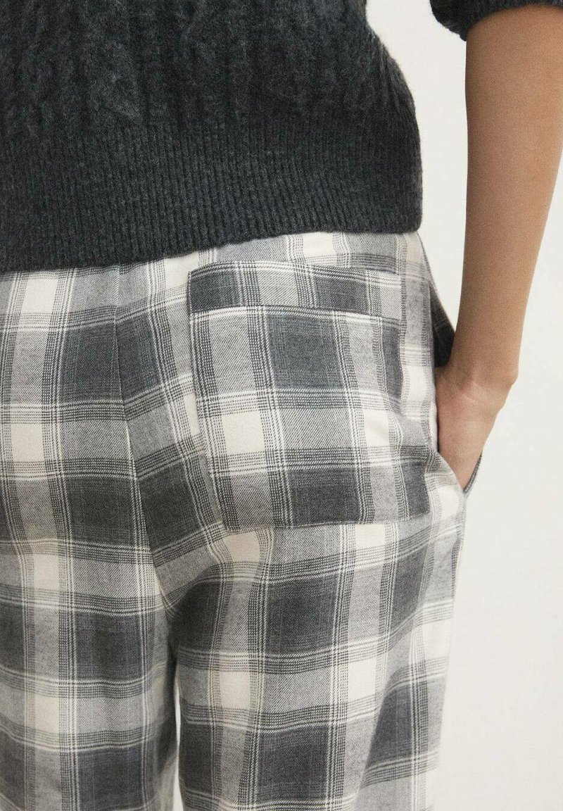 Ternede bukser med en blanding af grå og hvide farver, med en tekstureret linning og sidelomme detaljer.