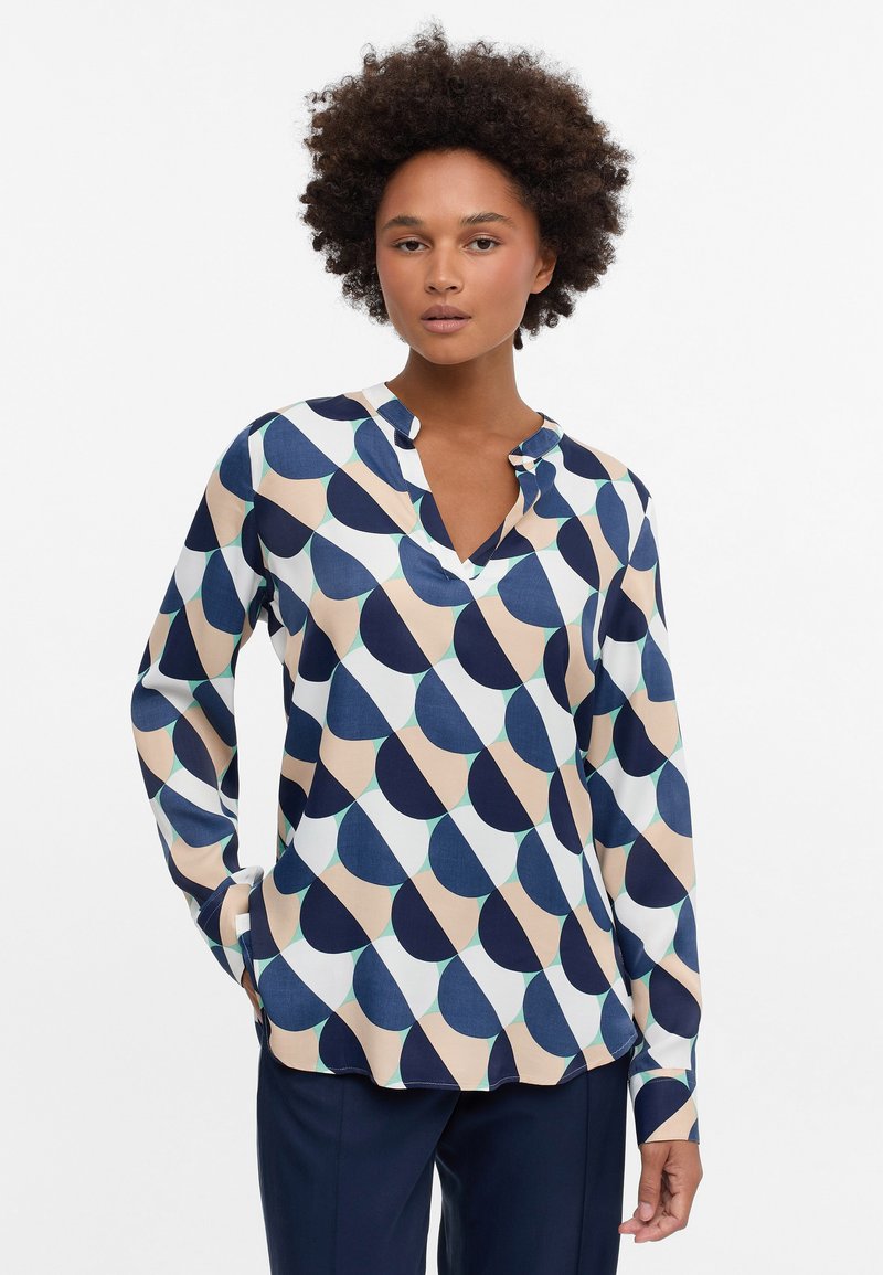 Langärmlige Bluse mit einem geometrischen Muster in Marineblau, Beige und Hellgrün. Leichter Stoff mit einem V-Ausschnitt und lockerer Passform.