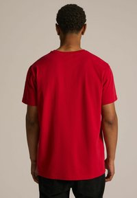 Czerwona bawełniana koszulka z krótkim rękawem i okrągłym dekoltem, charakteryzująca się gładką teksturą. Tył jest gładki, bez dodatkowych wzorów ani detali.