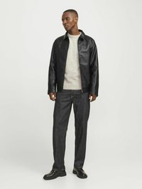 Chaqueta de cuero negra con acabado liso, suéter de punto gris, jeans de mezclilla oscura y zapatos negros. Diseño simple, sin patrones visibles.