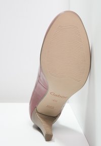 Chausson en cuir rose avec un talon effilé. Dispose d'une semelle en caoutchouc avec des rainures horizontales. Marque "Gabor" au fond, fabriqué au Portugal.