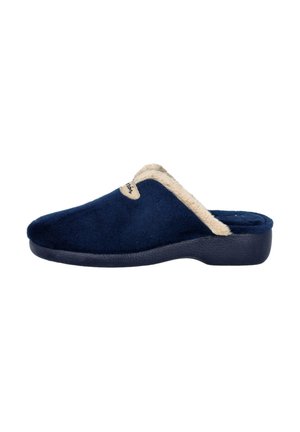 Pantufla azul marino con ribete beige de felpa, parte superior de tela suave, punta redondeada y suela negra texturizada para agarre. Diseñada para la comodidad.