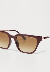 Ochelari de soare din plastic Bordeaux cu rame pătrate, lentile cu degradé maroniu și siglă embossată pe tâmplă. Textură netedă, design ușor.