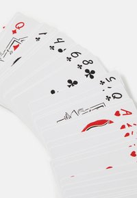 Playing cards arranged fanned out, featuring white backgrounds, red and black suits, and illustrations of face cards with Queens and Aces.