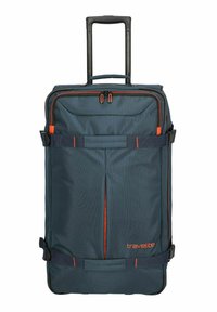 Sac de voyage à roulettes en tissu bleu foncé avec des accents orange. Dispose d'une poignée rétractable et de sangles ajustables pour sécuriser les objets.