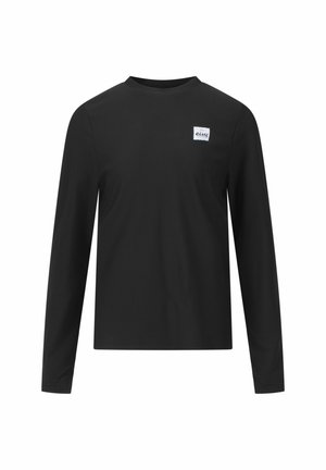 Chemise à manches longues noire avec une texture côtelée, col rond et une étiquette blanche carrée sur la poitrine gauche portant le nom de la marque.