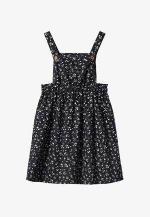 Robe sans manches bleu marine avec un motif floral blanc, taille froncée et bretelles fixées par des boutons en bois.