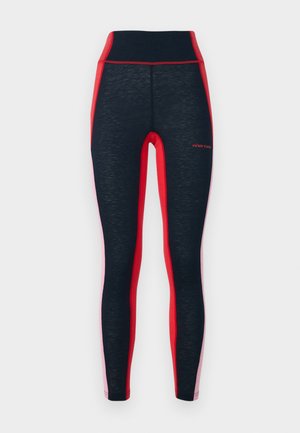 Svart og røde treningsstrømpebukser med høy midje, med kontrasterende sidepaneler og strukturert stoff. Logo vist på benet.