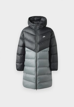 Polstret lang jakke med et farveblokdesign i sort og grå, hætte, lynlås foran og Nike-logo på venstre bryst. Glat tekstur.