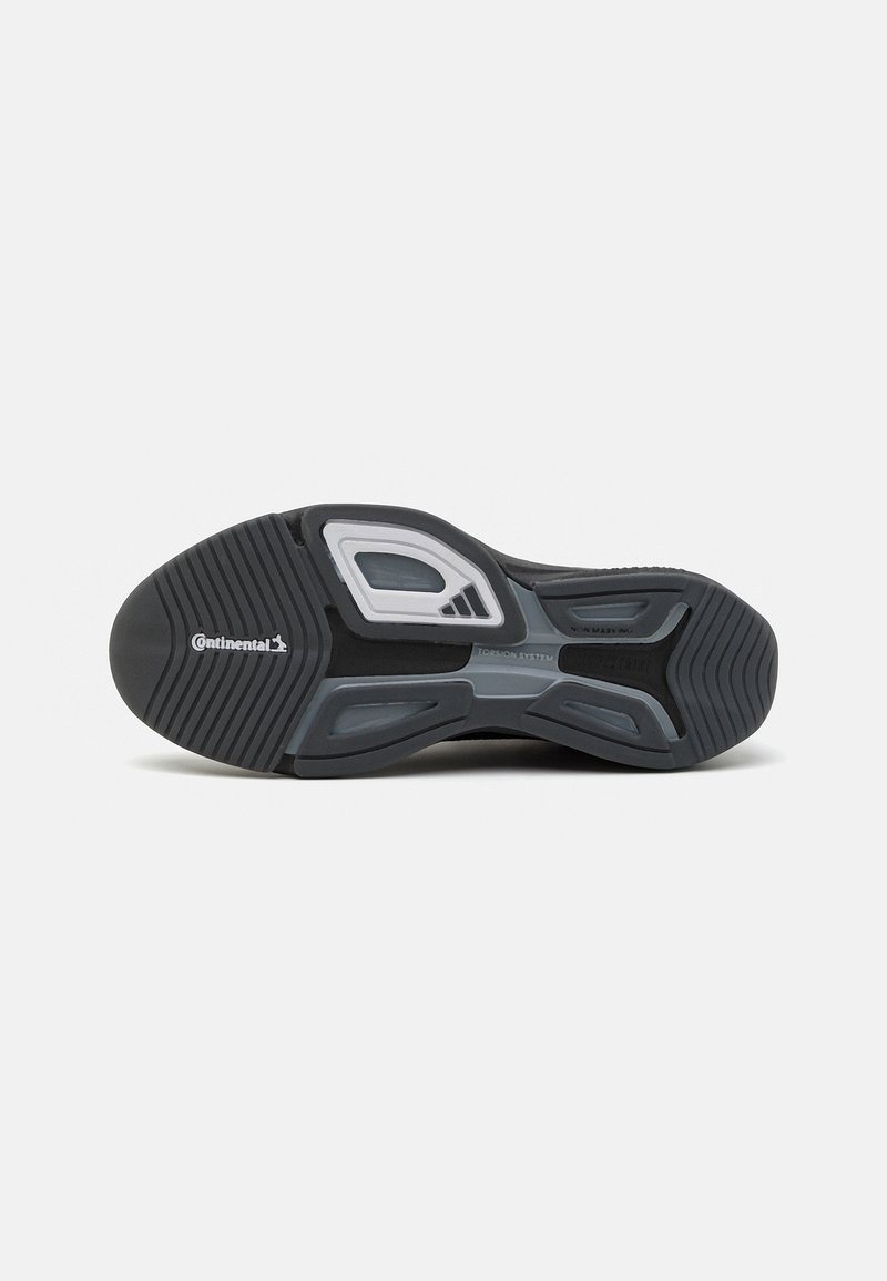 Suela de zapatilla deportiva negra con textura de goma. Presenta acentos grises y marcas, incluyendo "Continental" en blanco.