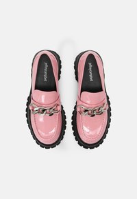 Roze lakleren loafers met een robuuste zwarte zool, voorzien van een zilveren kettingaccent over de bovenkant, ontworpen voor een moderne uitstraling.