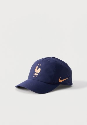 Casquette bleu marine avec un emblème doré de coq, deux étoiles au-dessus, « FFF » en dessous à l'avant, et un swoosh Nike doré sur le côté.
