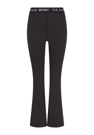 Leggings negros de corte acampanado hechos de un tejido elástico, con una cinturilla blanca con la marca. Textura suave y silueta ajustada.