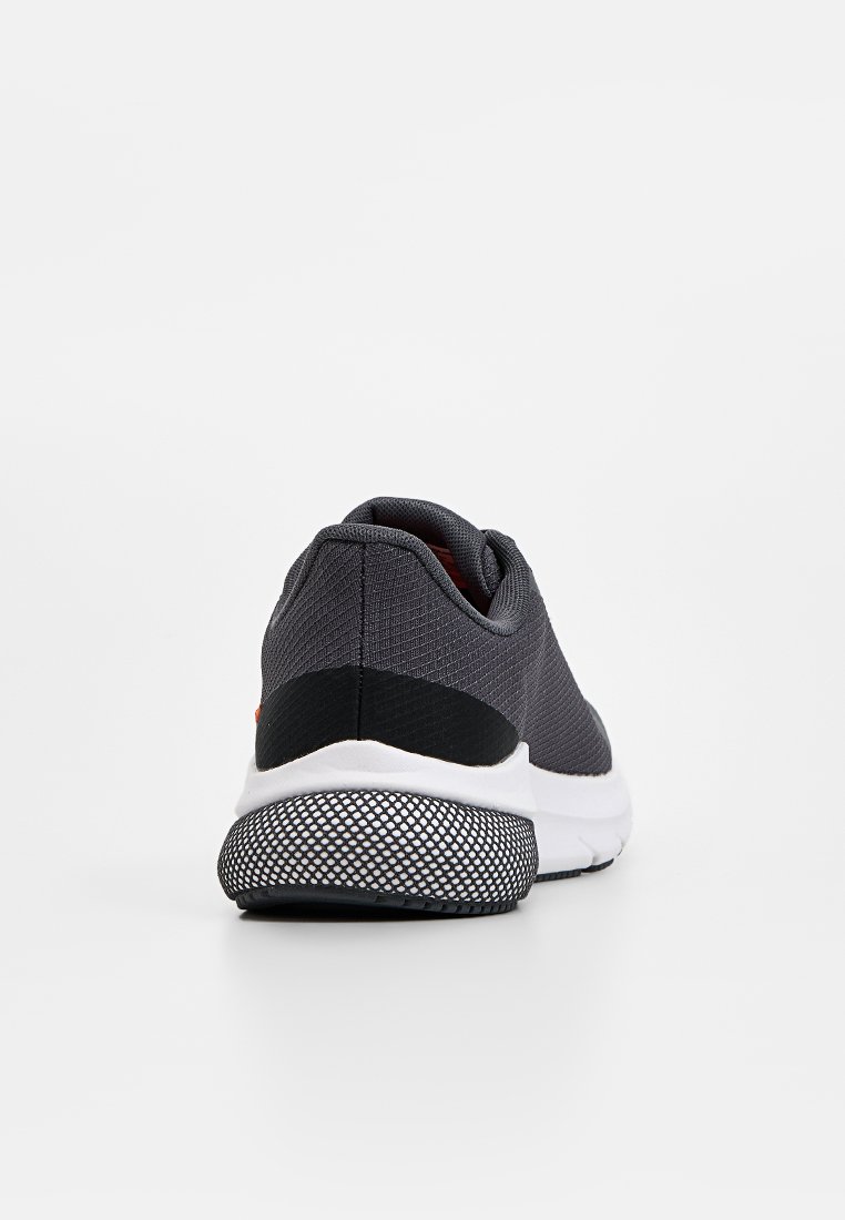Graue Sportschuh mit einer strukturierten Oberseite, schwarzen Akzenten, einer gepolsterten weißen Zwischensohle und einer gemusterten schwarzen Außensohle.