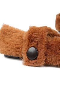 Brązowe, puszyste sandały o miękkiej fakturze z czarnym, okrągłym guzikiem jako akcentem. Zaprojektowane z szerokimi paskami dla komfortu i wsparcia.